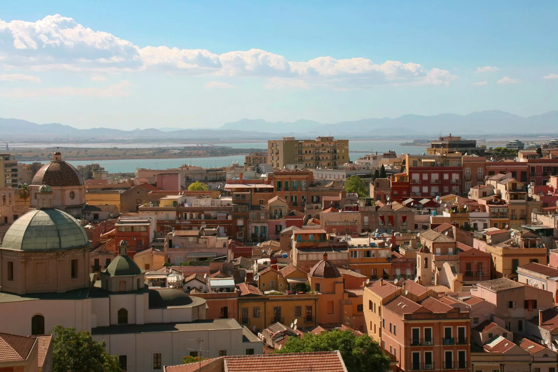 View over the rooftops and domes of Cagliari old town toward the sea, southern Sardinia