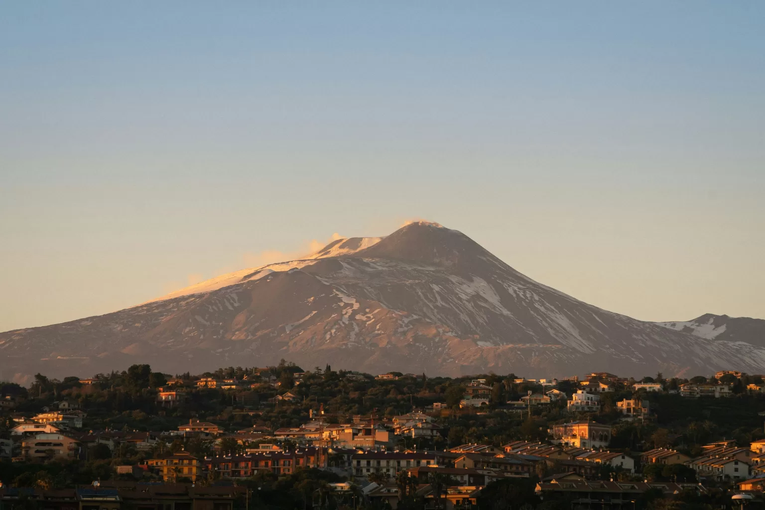 Snow-covered Mount Etna towering over Catania, Sicily