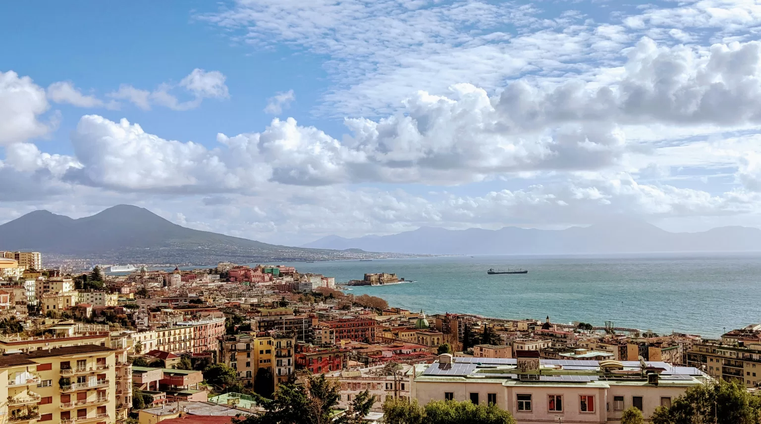 Naples city buildings near the sea under a blue sky