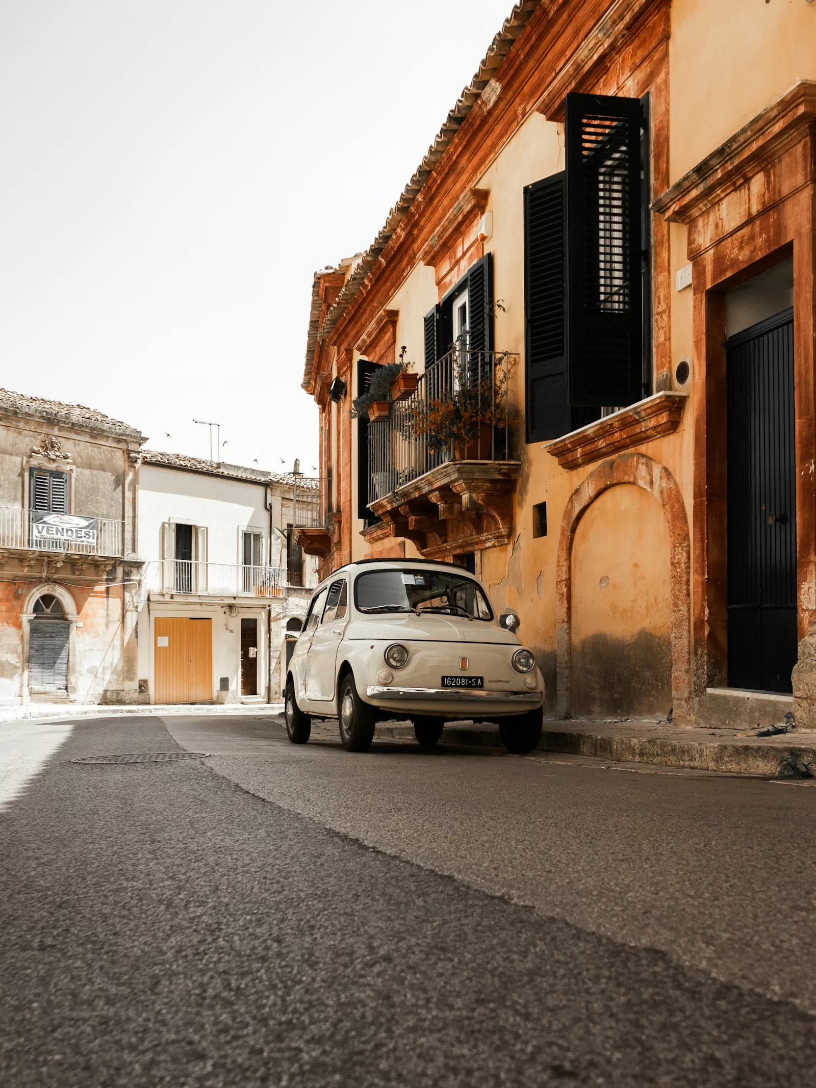 Fiat 500 parked on a narrow Sicilian street, the parking reality after car rental at Trapani Airport