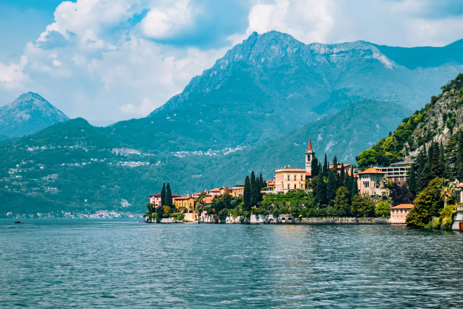 A village with a bell tower and a villa on Lake Como, where Como town is about 53 minutes by car from Milan Linate Airport