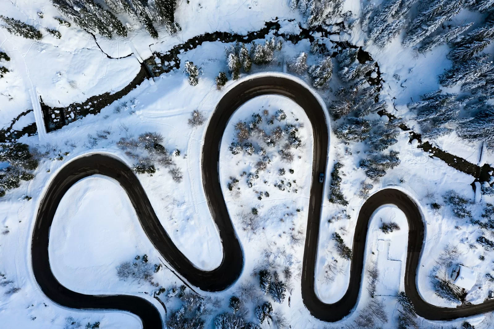 Aerial view of snowy hairpin bends on the road over Passo Staulanza in the Dolomites