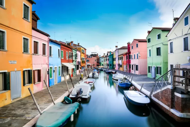 Colourful houses along a canal in the Venice lagoon, where cars cannot go; Piazzale Roma is about 19 minutes by car from Venice Marco Polo Airport